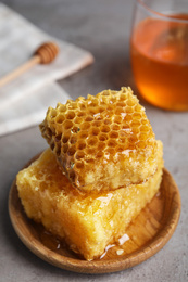 Photo of Fresh delicious honeycombs on grey table, closeup