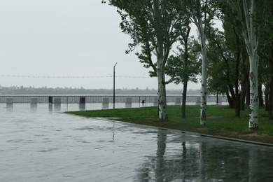 Empty city embankment under heavy rain on spring day