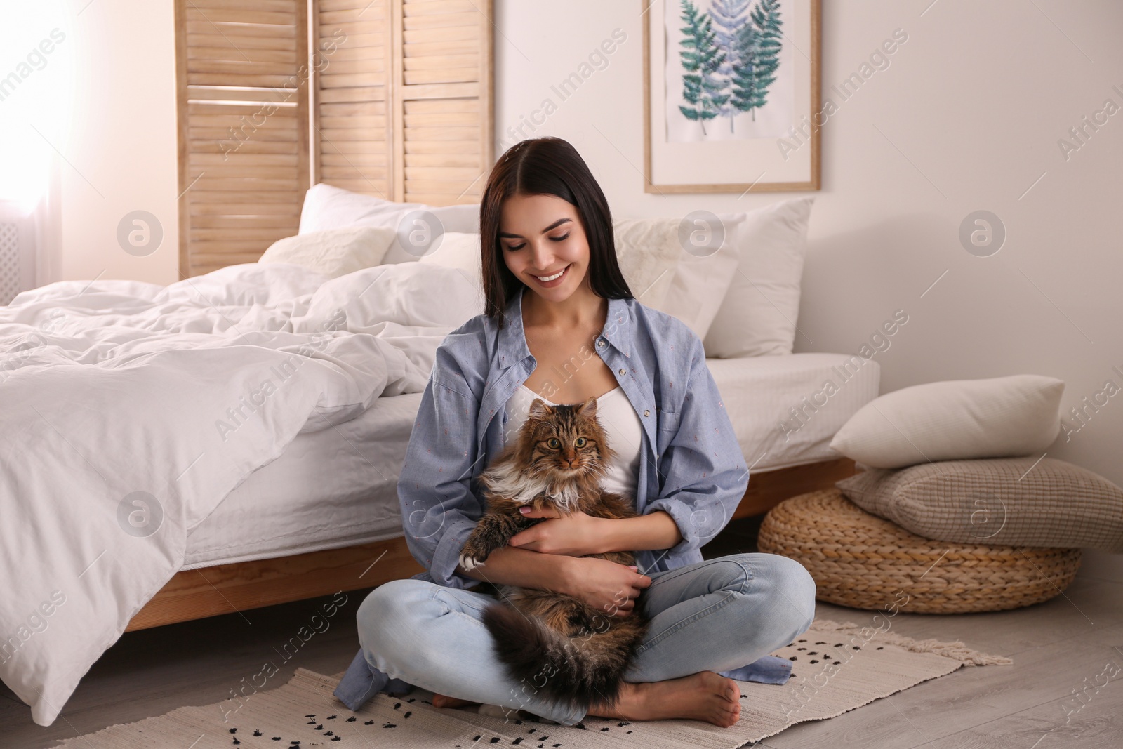 Photo of Beautiful young woman with her cute cat on floor in bedroom. Fluffy pet