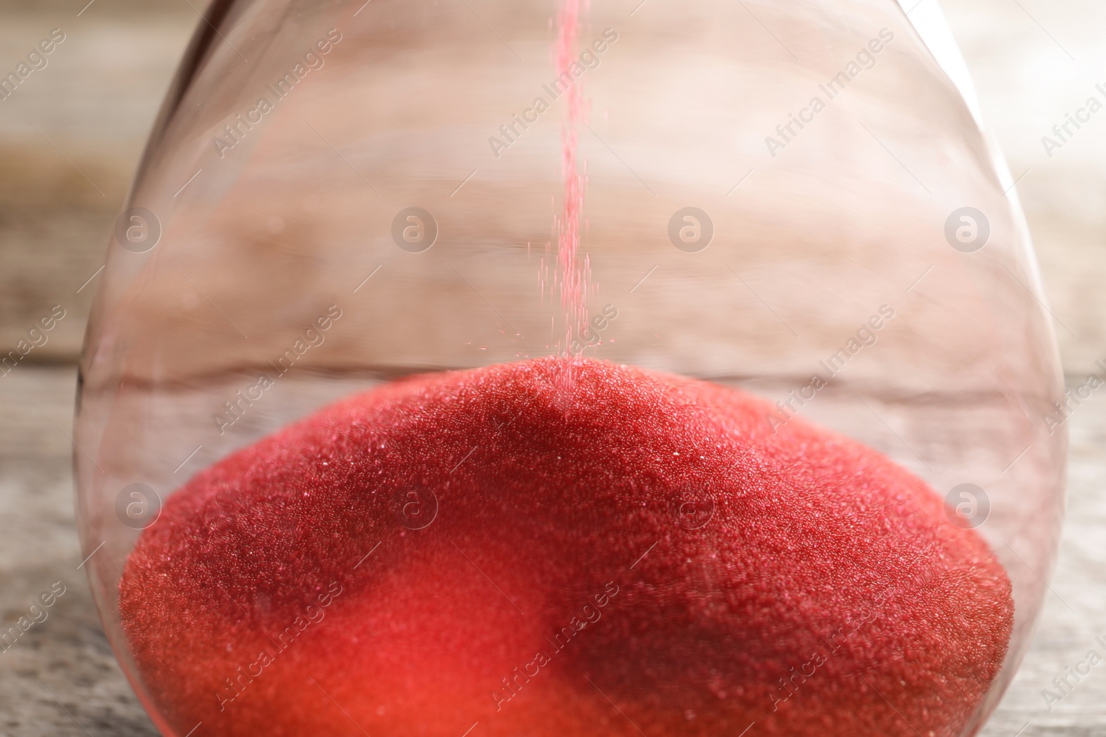 Photo of Hourglass with flowing sand on table, closeup. Time management