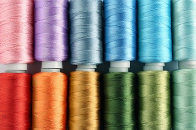 Set of colorful sewing threads as background, top view