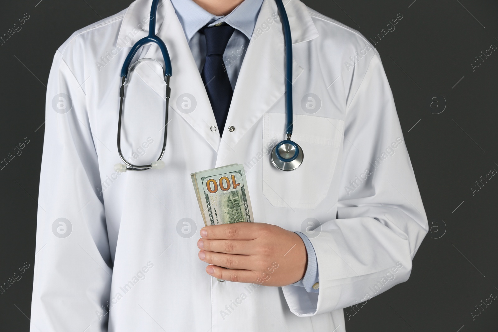 Photo of Doctor with bribe on black background, closeup. Corruption in medicine