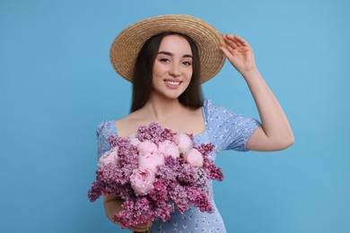 Photo of Beautiful woman with bouquet of spring flowers on light blue background