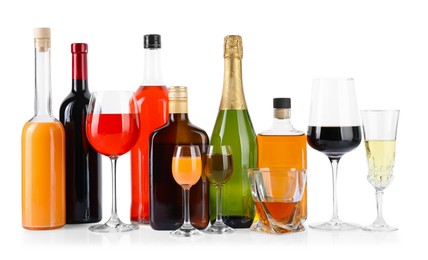 Photo of Bottles and glasses with different alcoholic drinks isolated on white