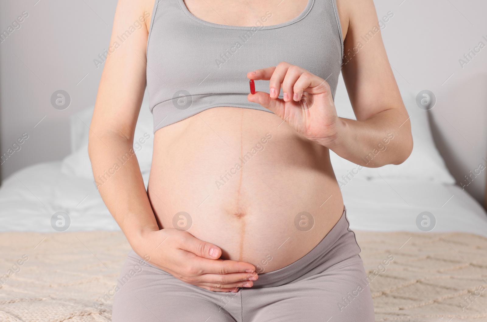 Photo of Pregnant woman taking pill at home, closeup