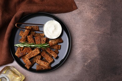 Photo of Crispy rusks with rosemary and sauce on grey table, flat lay. Space for text