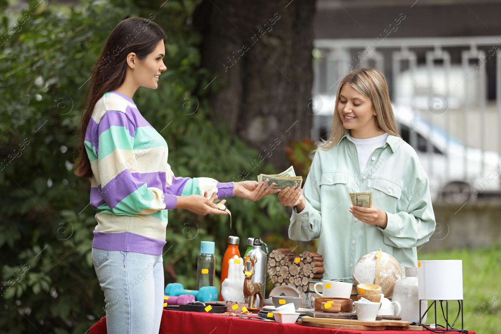 Photo of Woman buying watch on garage sale in yard