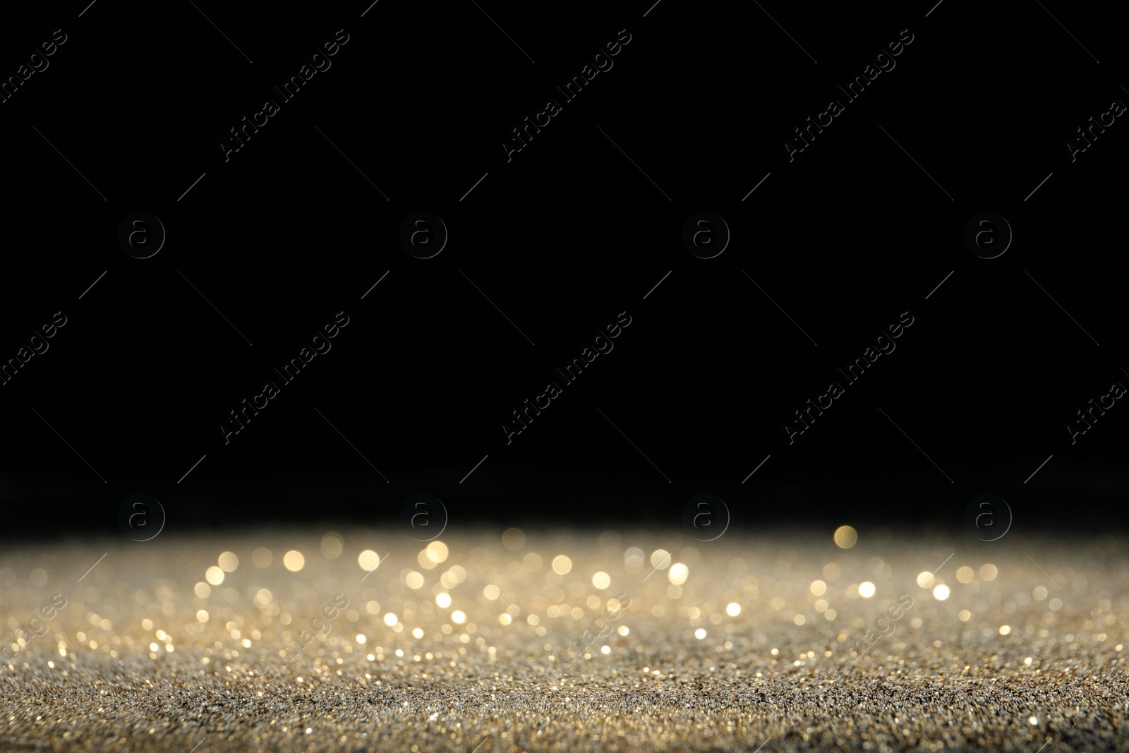 Photo of Shiny golden glitter on black background, space for text. Bokeh effect