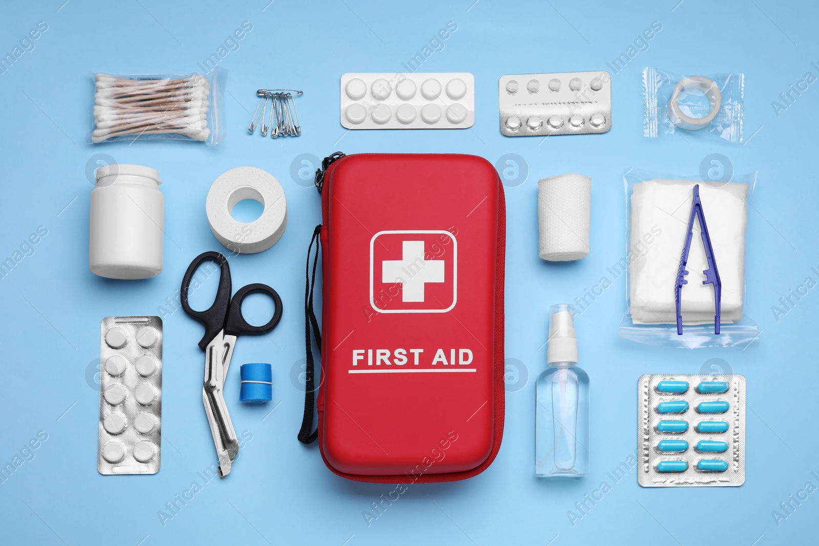 Photo of Flat lay composition with first aid kit on light blue background