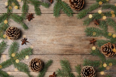 Photo of Christmas greeting card with space for text. Flat lay composition of fir tree branches on wooden background