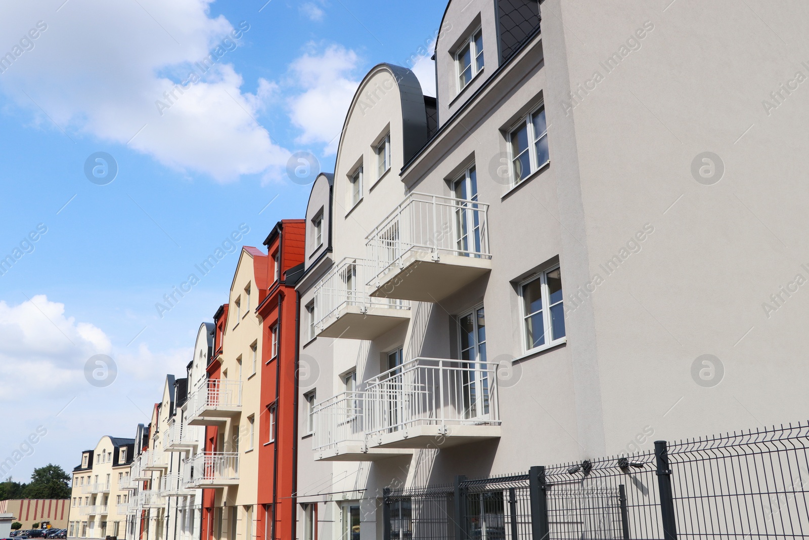 Photo of Beautiful view of modern houses with balconies against blue sky