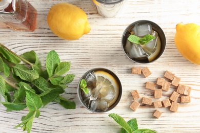 Flat lay composition with delicious mint julep cocktail on wooden background