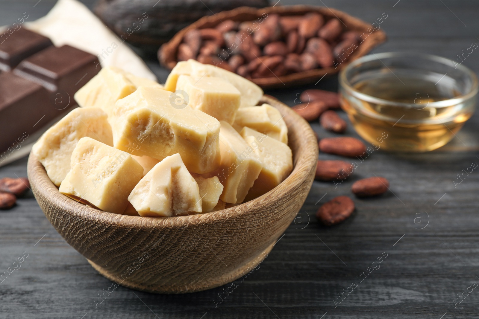 Photo of Organic cocoa butter on black wooden table, closeup