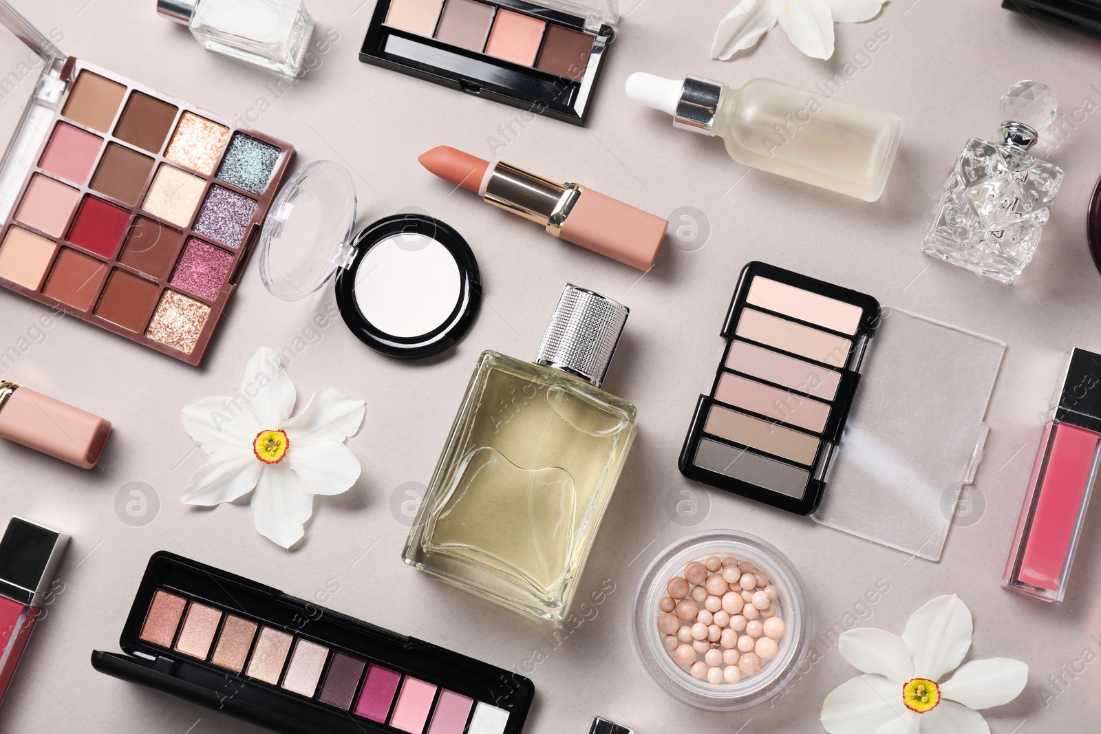 Photo of Flat lay composition with different makeup products and beautiful spring flowers on grey background