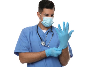 Doctor in protective mask putting on medical gloves against white background