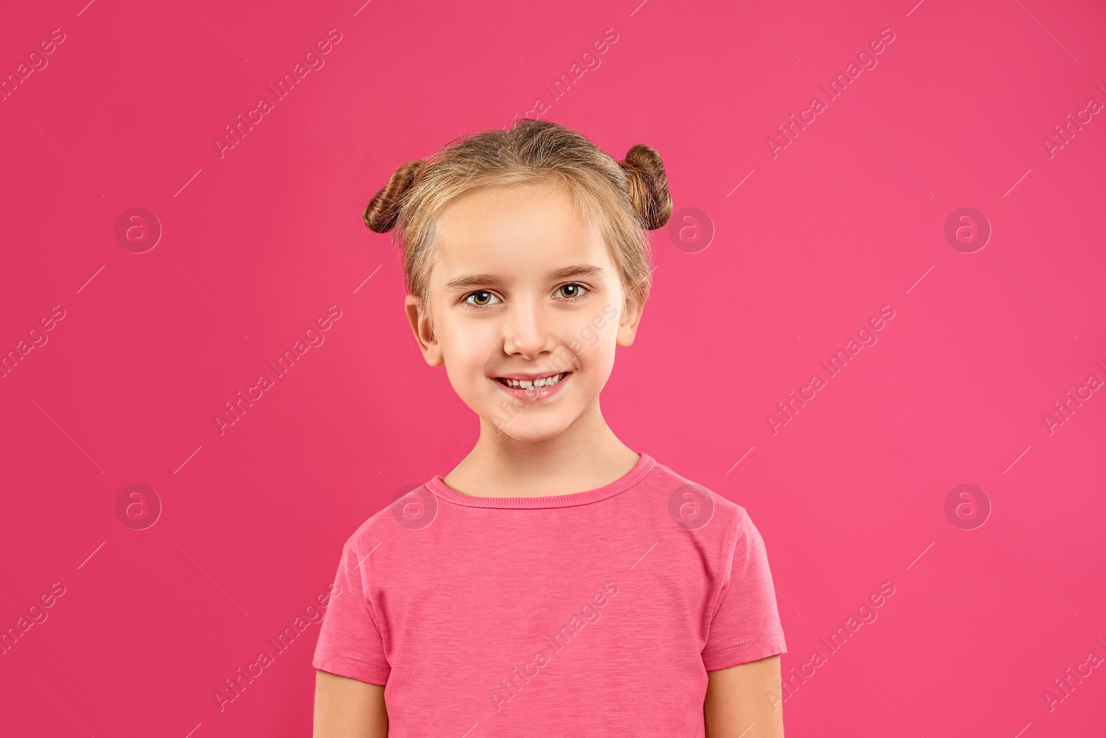 Photo of Cute little girl posing on pink background