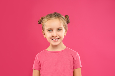 Photo of Cute little girl posing on pink background