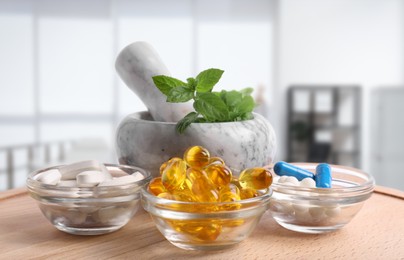 Image of Mortar with fresh mint and pills on wooden surface in medical office