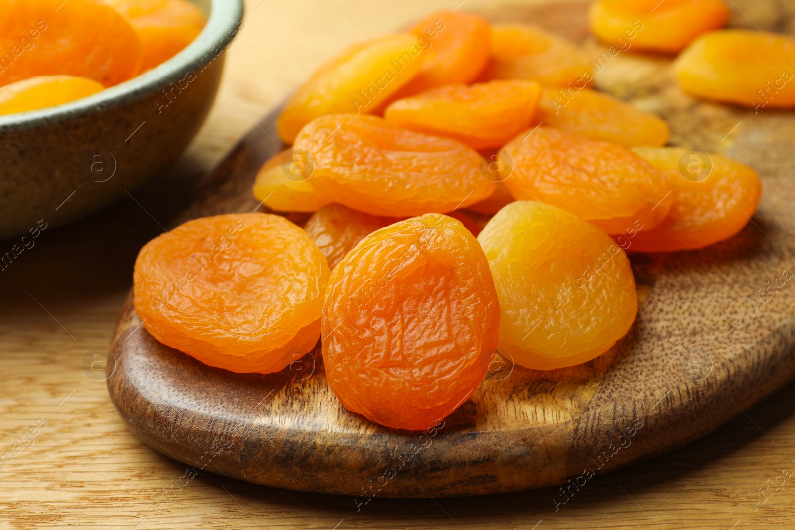 Photo of Tasty apricots on wooden table, closeup. Dried fruits