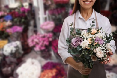 Image of Florist holding beautiful wedding bouquet on shop, closeup. Space for text 