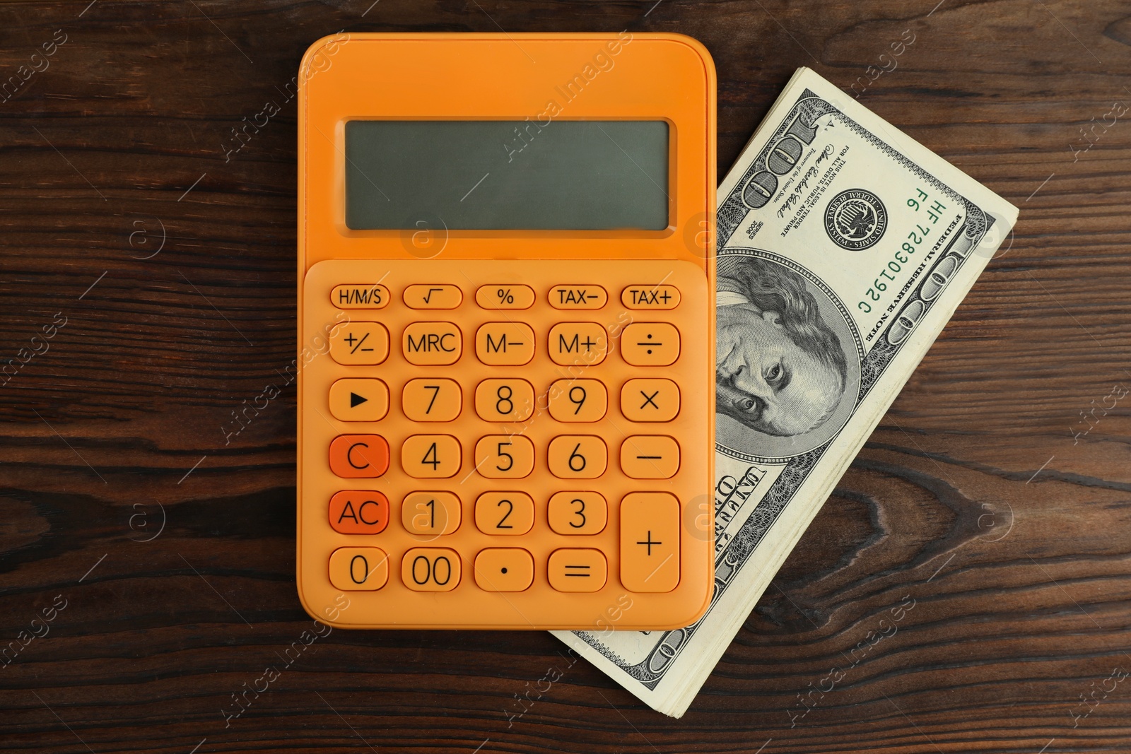 Photo of Money exchange. Dollar banknotes and calculator on wooden background, top view