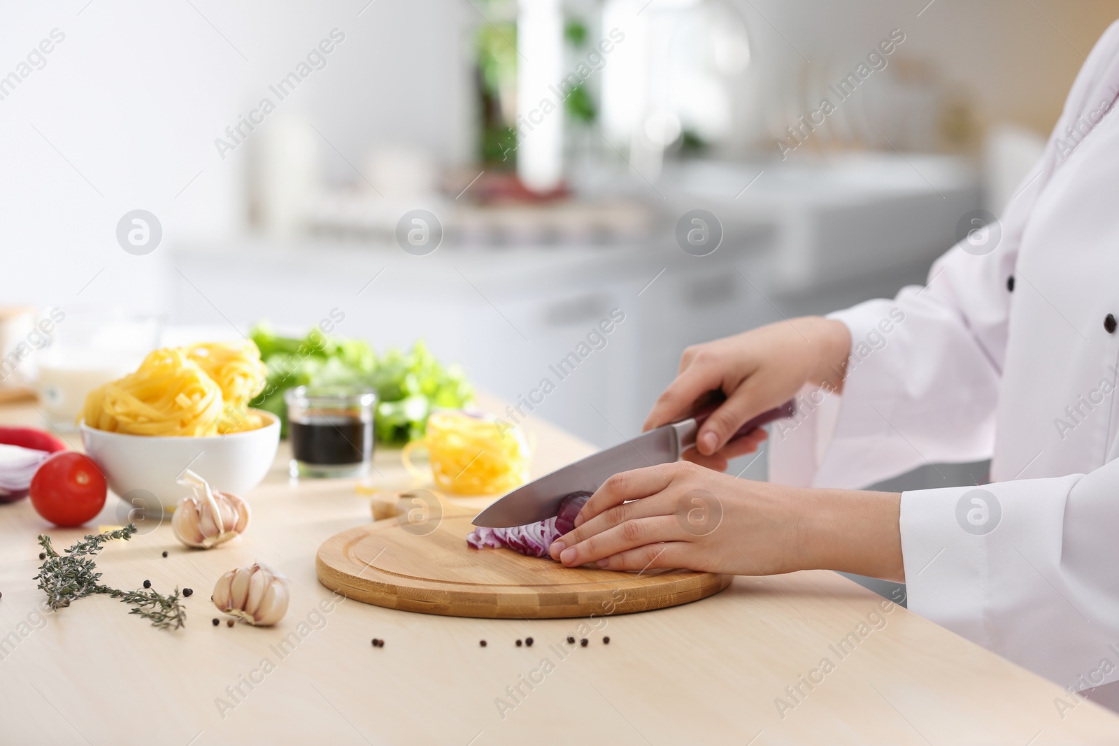 Photo of Female chef cooking food at kitchen table, closeup