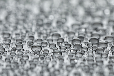 Water drops on grey background, closeup view