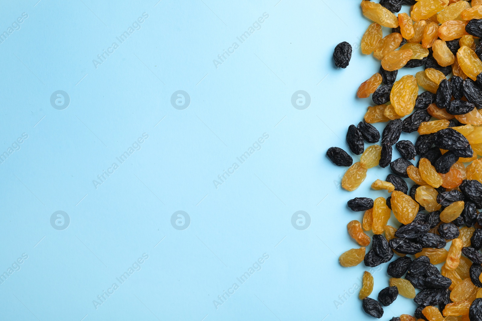 Photo of Many raisins on color background, top view with space for text. Dried fruit as healthy snack