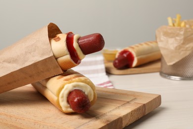 Delicious french hot dogs and fries on white wooden table. Space for text
