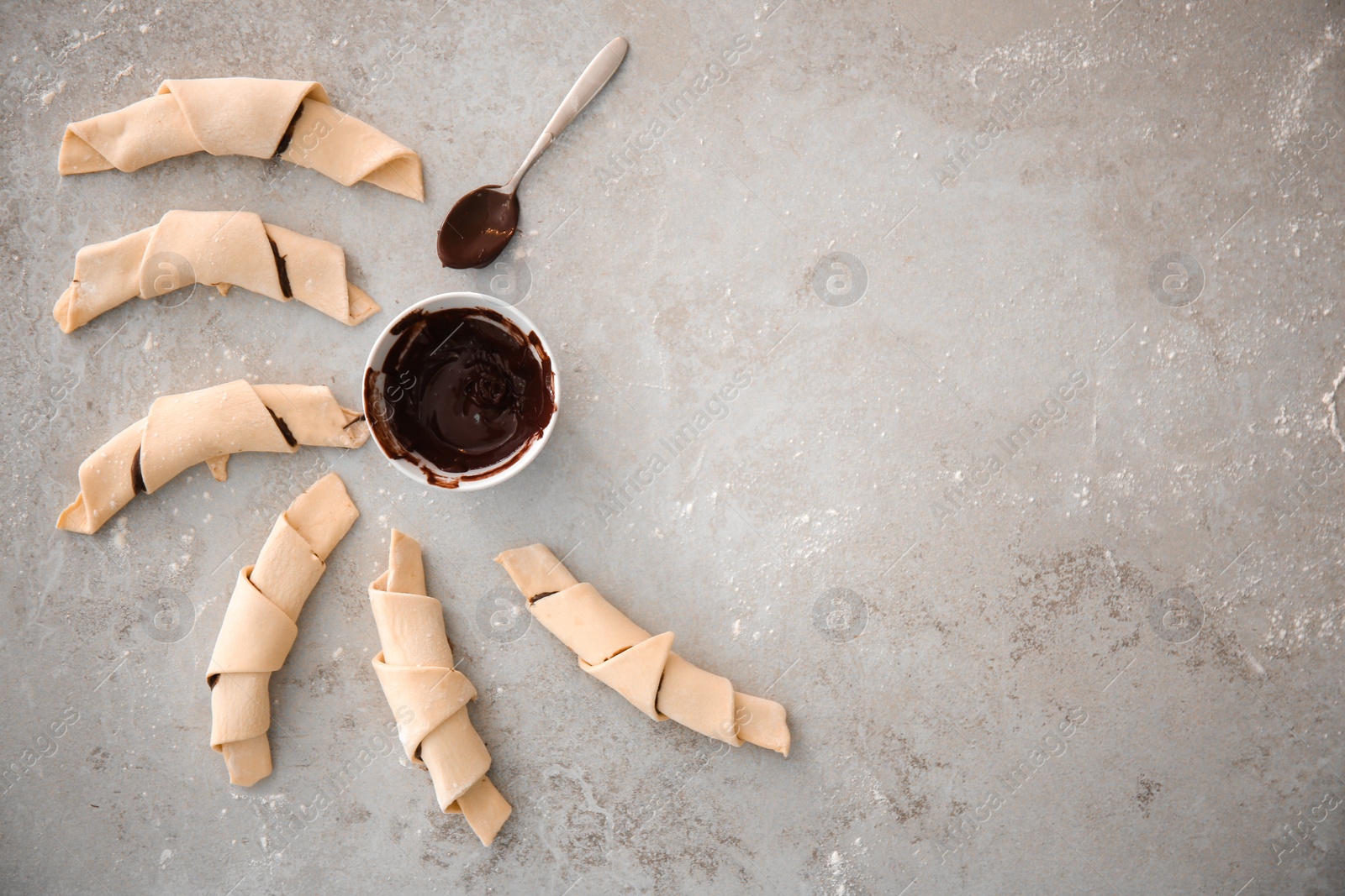 Photo of Flat lay composition with raw croissants and chocolate paste on grey background