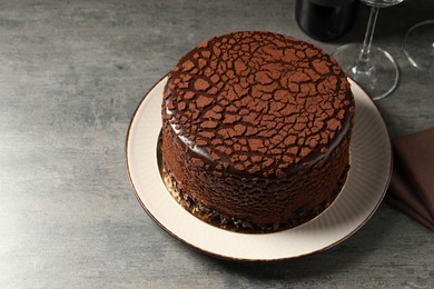 Photo of Delicious chocolate truffle cake on grey textured table, space for text