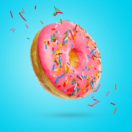 Delicious donut falling on light blue background