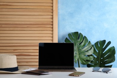 Photo of Modern laptop, smartphone and passports with tickets on white table. Space for design