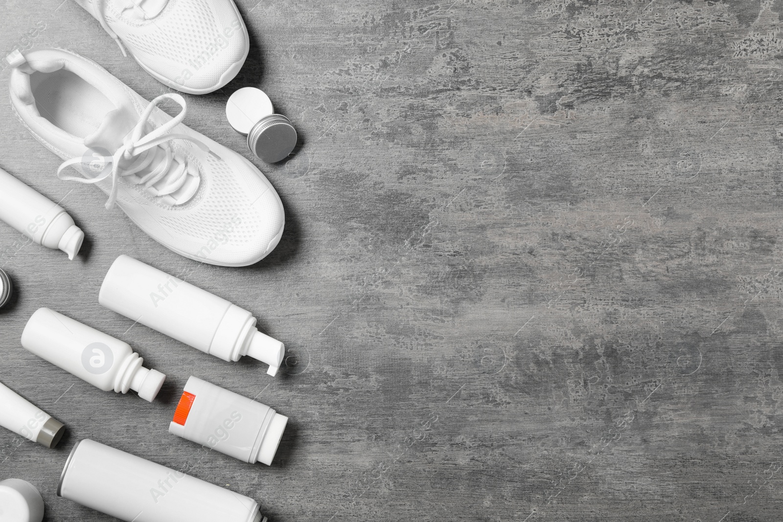 Photo of Flat lay composition with stylish footwear and shoe care accessories on grey background, space for text