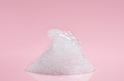 Photo of Drop of fluffy bath foam on pink background