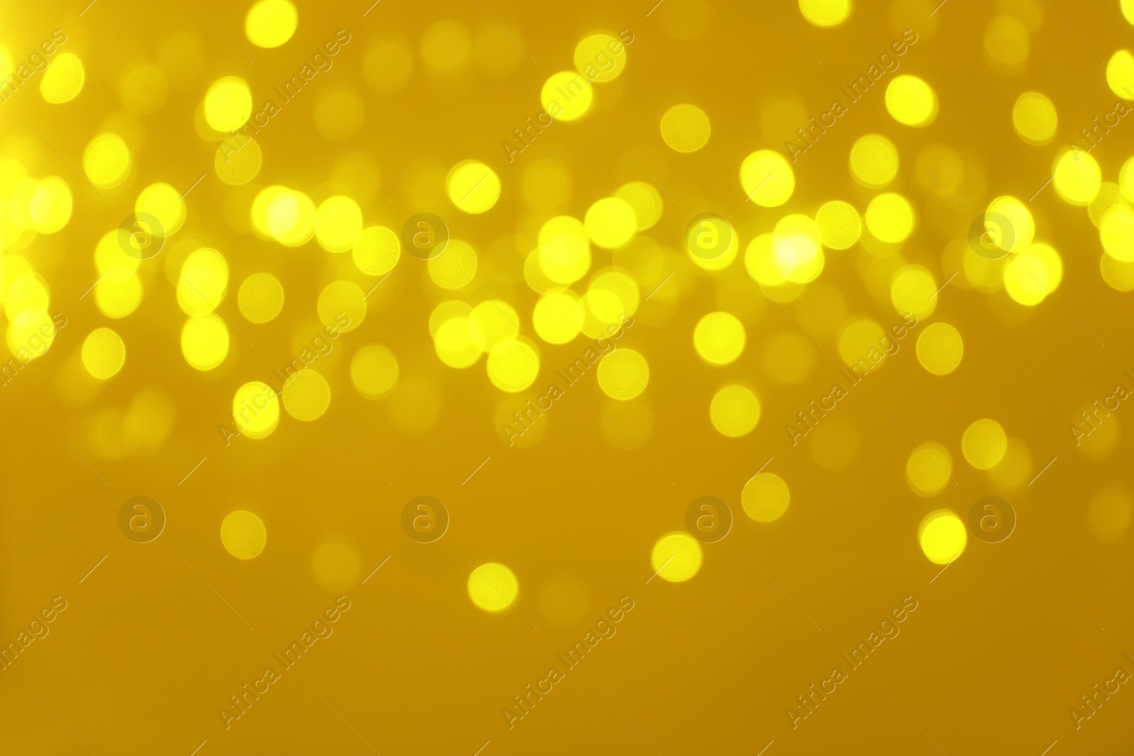 Photo of Blurred view of shiny gold lights. Bokeh effect