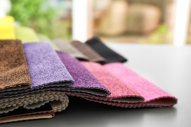 Photo of Fabric samples of different colors for interior design on table