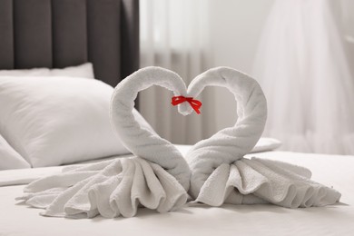 Honeymoon. Swans made of towels on bed in room