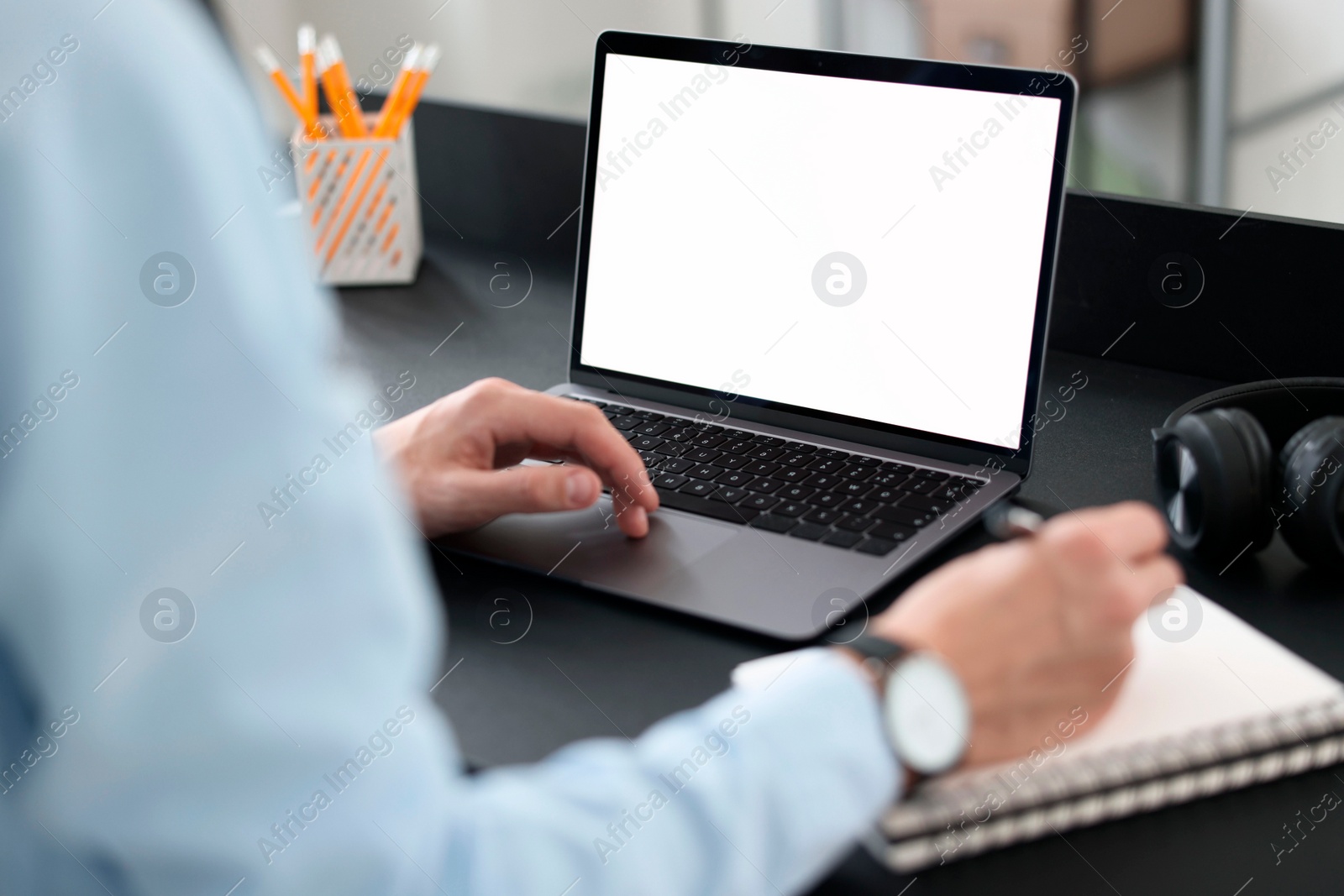 Photo of Man taking notes during webinar at table in office, closeup