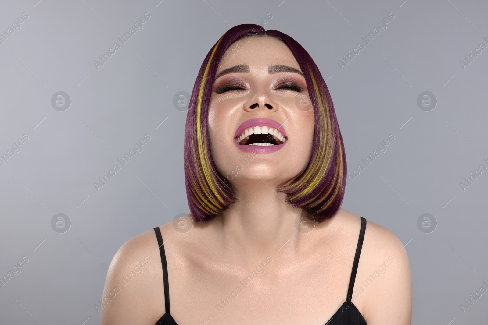 Image of Hair styling. Attractive woman with colorful hair on grey background