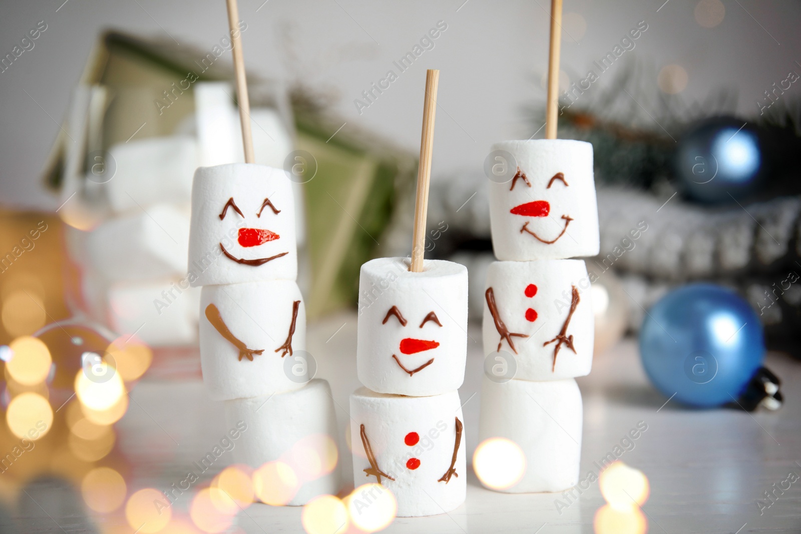 Image of Funny snowmen made of marshmallows on white table. Bokeh effect