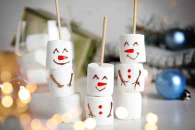 Image of Funny snowmen made of marshmallows on white table. Bokeh effect