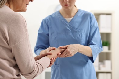 Photo of Arthritis symptoms. Doctor examining patient's wrist in hospital, closeup