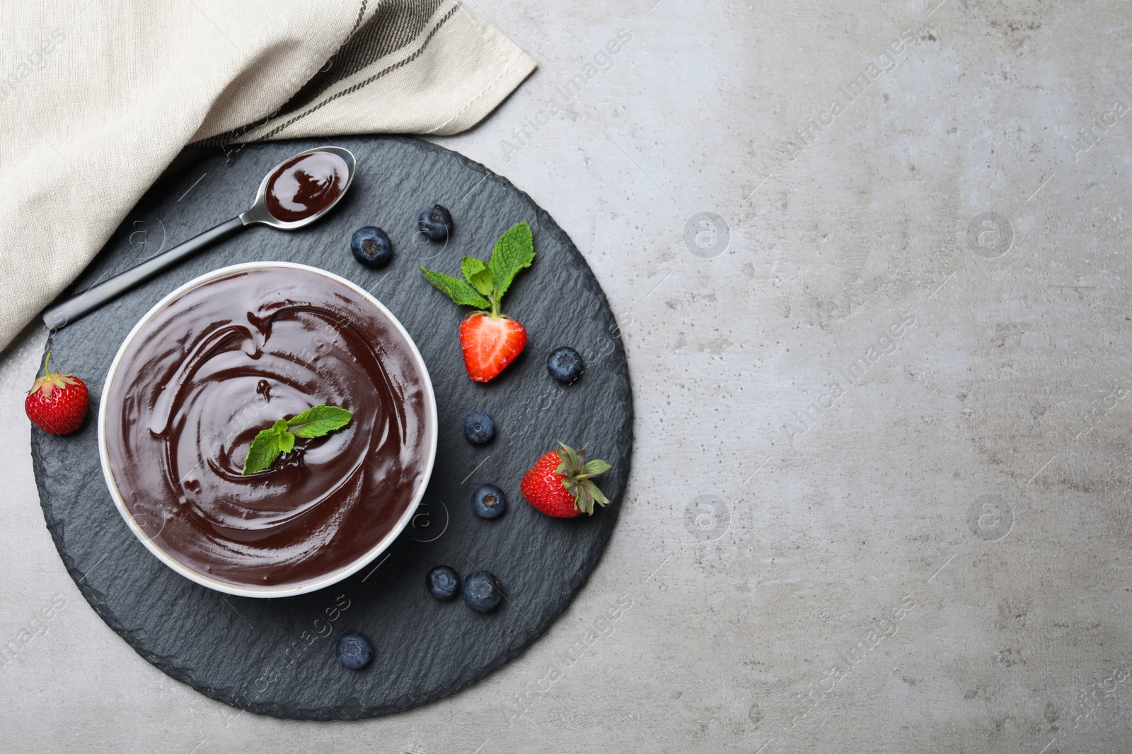 Photo of Delicious chocolate cream with berries and mint on grey table, top view. Space for text