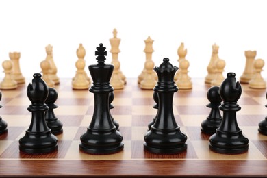 Photo of Chess pieces on wooden board against white background