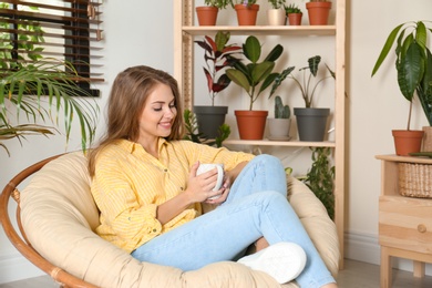 Young woman resting in room with different home plants