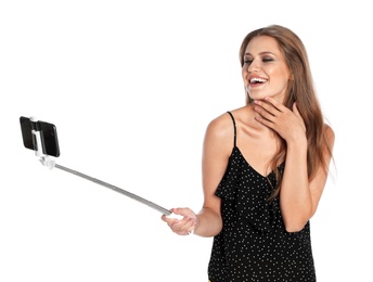 Happy young woman taking selfie on white background