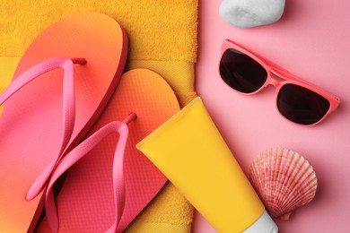 Photo of Flat lay composition with sunscreen and beach accessories on pink background