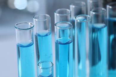 Photo of Test tubes with light blue liquid in laboratory, closeup