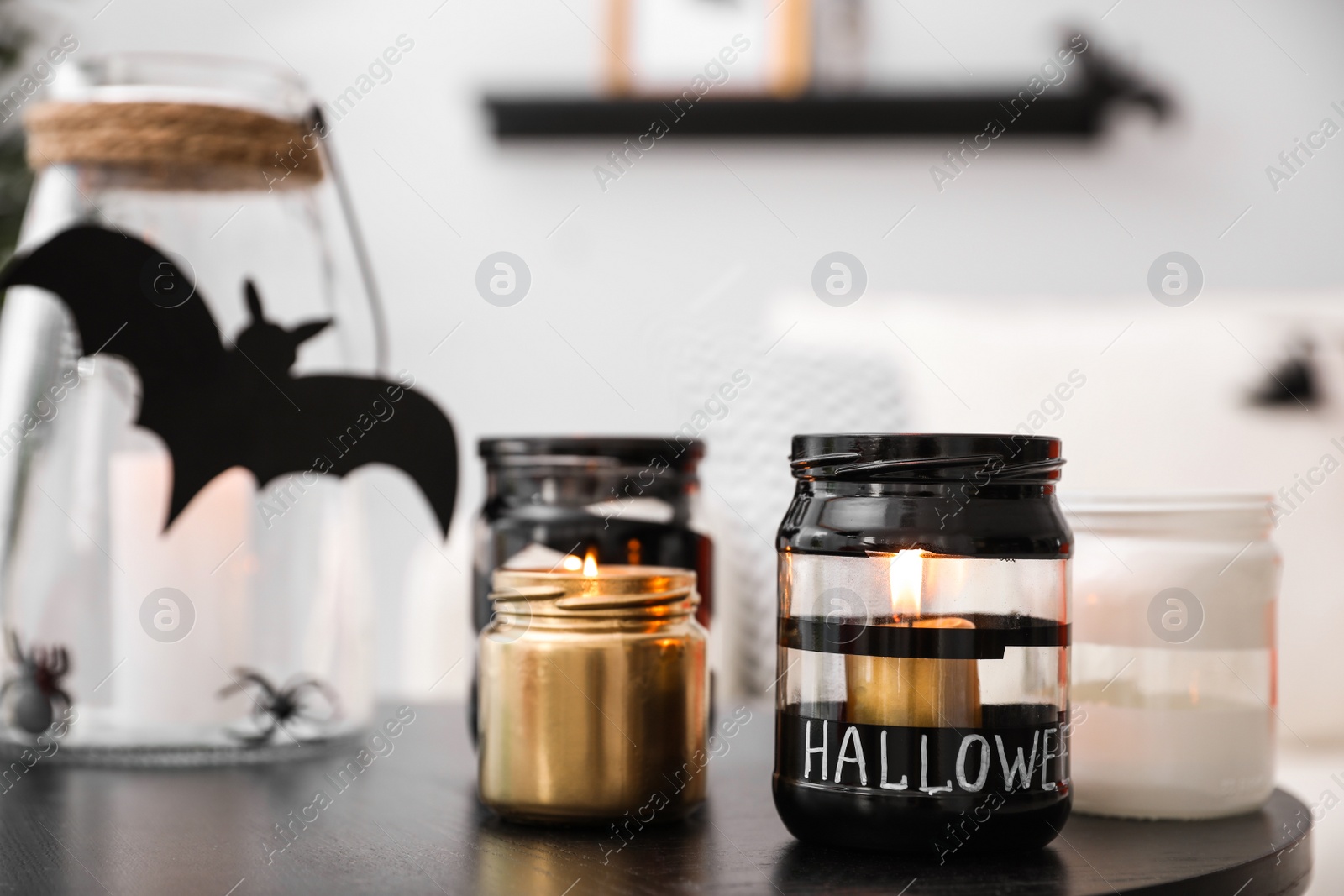 Photo of Burning candles on table in room. Idea for Halloween interior